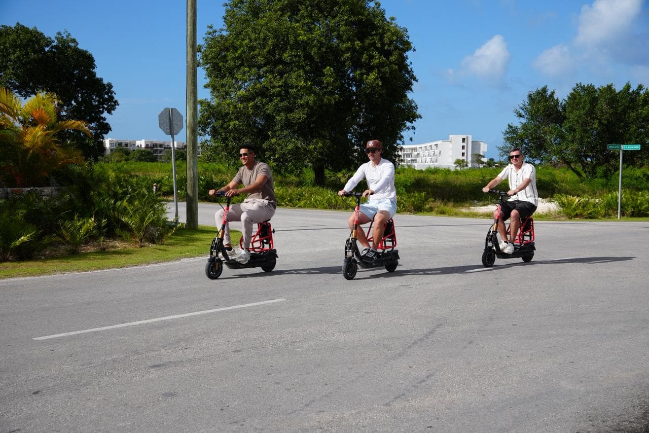 Three riders cruising through Vista Cana on Brisa Ride electric scooters